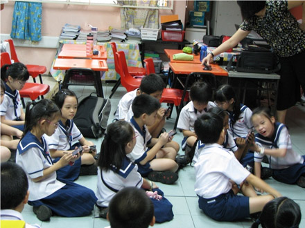 Photo of 3rd grade students  from Singapore using mobile computers in a conversational manner