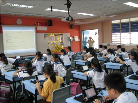 Photo of 5th grade students  from Singapore using computers that are tethered to desks